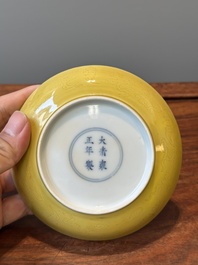 A pair of Chinese monochrome yellow-glazed saucers with incised designs of pine and cranes, Yongzheng mark and of the period