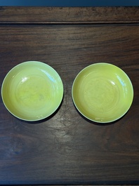 A pair of Chinese monochrome yellow-glazed saucers with incised designs of pine and cranes, Yongzheng mark and of the period