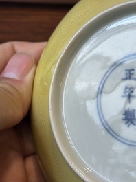 A pair of Chinese monochrome yellow-glazed saucers with incised designs of pine and cranes, Yongzheng mark and of the period