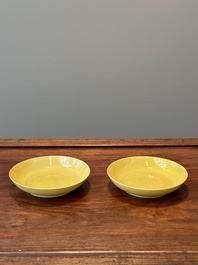 A pair of Chinese monochrome yellow-glazed saucers with incised designs of pine and cranes, Yongzheng mark and of the period