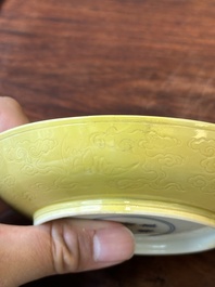 A pair of Chinese monochrome yellow-glazed saucers with incised designs of pine and cranes, Yongzheng mark and of the period