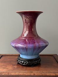 A Chinese flamb&eacute;-glazed vase on a wooden stand, 19th C.