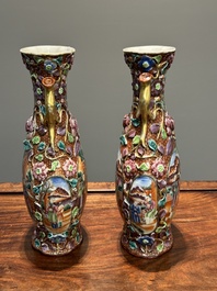 A pair of Chinese Canton famille rose 'mandarin subject' vases with floral relief design, Qianlong