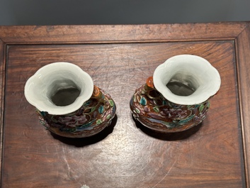 A pair of Chinese Canton famille rose 'mandarin subject' vases with floral relief design, Qianlong