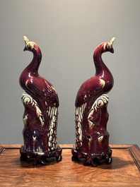 A pair of Chinese flamb&eacute;-glazed models of peacocks on wooden stands, 19th C.