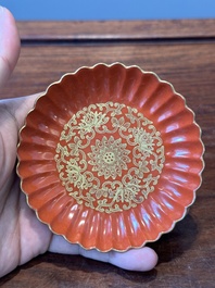 A Chinese coral-red-glazed gilt-decorated 'lotus scroll' saucer, Jiaqing mark, Republic