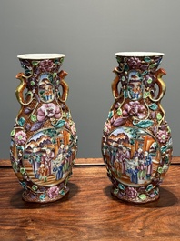 A pair of Chinese Canton famille rose 'mandarin subject' vases with floral relief design, Qianlong