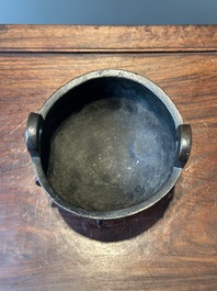 A Chinese archaistic bronze tripod censer on wooden stand, 'ding', Song/Ming