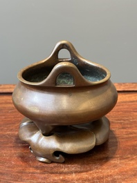 A Chinese bronze tripod censer on a stand, Xuande mark, 19th C.