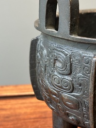 A Chinese archaistic bronze tripod censer on wooden stand, 'ding', Song/Ming