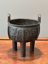 A Chinese archaistic bronze tripod censer on wooden stand, 'ding', Song/Ming