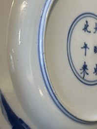 A Chinese blue and white plate with a breastfeeding woman and fishermen on boats, Chenghua mark, Kangxi
