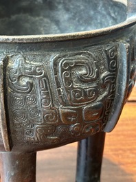 A Chinese archaistic bronze tripod censer on wooden stand, 'ding', Song/Ming