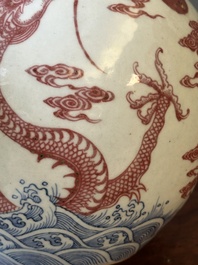 Een Chinese blauw-witte en koperrode 'tianqiu' ping vaas met draken tussen vlammen en wolken, 18e eeuw