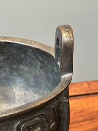 A Chinese archaistic bronze tripod censer on wooden stand, 'ding', Song/Ming