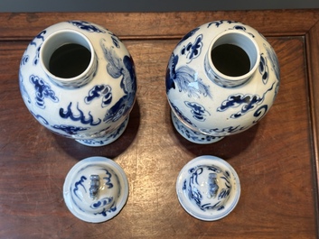 A pair of Chinese blue and white covered vases and three jars, 19th C.