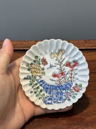 A Chinese famille rose relief-decorated cup and saucer, Yongzheng