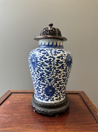A Chinese blue and white 'lotus scroll' jar with wooden cover and stand, Kangxi