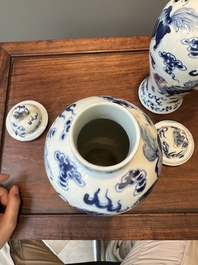 A pair of Chinese blue and white covered vases and three jars, 19th C.