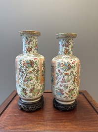 A pair of Chinese Canton famille rose vases with wooden stands, 19th C.