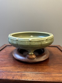 A Chinese Longquan celadon tripod censer on wooden stand, Yuan/Ming