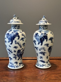 A pair of Chinese blue and white covered vases and three jars, 19th C.