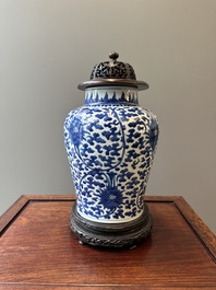 A Chinese blue and white 'lotus scroll' jar with wooden cover and stand, Kangxi