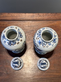 A pair of Chinese blue, white and copper-red vases and covers, Kangxi mark, 19th C.