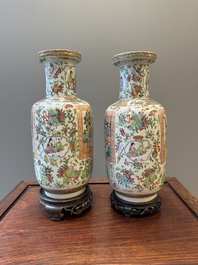 A pair of Chinese Canton famille rose vases with wooden stands, 19th C.