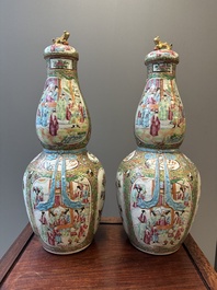 A pair of Chinese Canton famille rose double gourd vases and covers, 19th C.