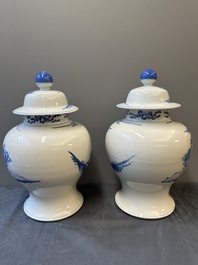 A pair of Chinese blue and white covered vases with figural design, 19th C.