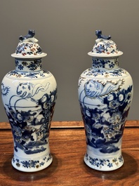 A pair of Chinese blue, white and copper-red vases and covers, Kangxi mark, 19th C.