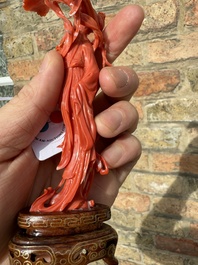 A Chinese red coral figure of a standing lady holding a flower, 19/20th C.