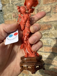 A Chinese red coral figure of a standing lady holding a flower, 19/20th C.