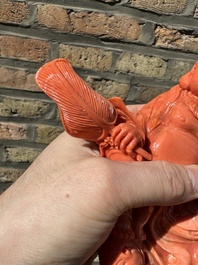 A Chinese red coral figure of a laughing Buddha on wooden stand, 19/20th C.