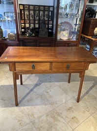 A Chinese huanghuali wooden two-drawer recessed-leg table, 19/20th C.