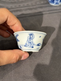 Thirteen Chinese blue and white saucers and twelve cups with figural design, Kangxi/Yongzheng