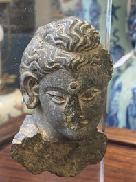 Two small Gandhara grey schist Bodhisattva heads, a stucco sculpture of Bodhisattva and a stucco female head, 1/4th C.