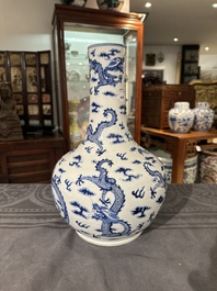 A Chinese blue and white bottle vase with dragons among flames and clouds, 19th C.