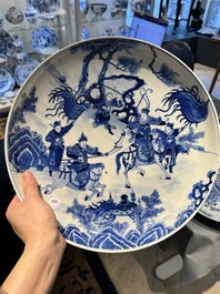 Plat en porcelaine de Chine en bleu et blanc &agrave; d&eacute;cor de guerriers &agrave; cheval, 19&egrave;me