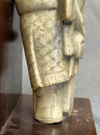 Een Chinese deels gepolychromeerde zeepstenen figuur op houten sokkel, 18e eeuw