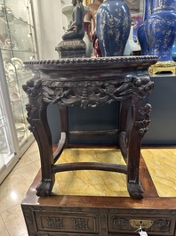 A Chinese carved wooden stand and a low table with marble tops, 19th C.
