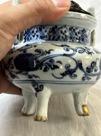 Een Chinees blauw-wit wierookvat op drie poten met floraal decor en een houten deksel, Ming