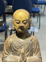 A Chinese gilt cast iron figure of a standing monk, Ming
