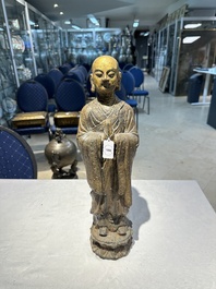 Een Chinese vergulde gietijzeren figuur van een staande monnik, Ming