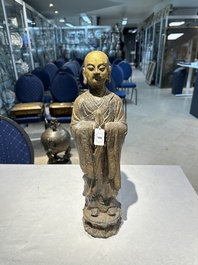 A Chinese gilt cast iron figure of a standing monk, Ming