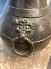 Vase de forme 'hu' en bronze aux anses en forme de taotie dans le style de Han sur socle en bois, Chine, Ming