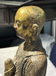 A Chinese gilt cast iron figure of a standing monk, Ming