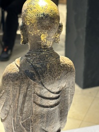 A Chinese gilt cast iron figure of a standing monk, Ming