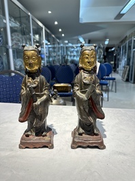 Een paar Chinese deels gelakt en verguld bronzen vrouwelijke bedienden, Ming